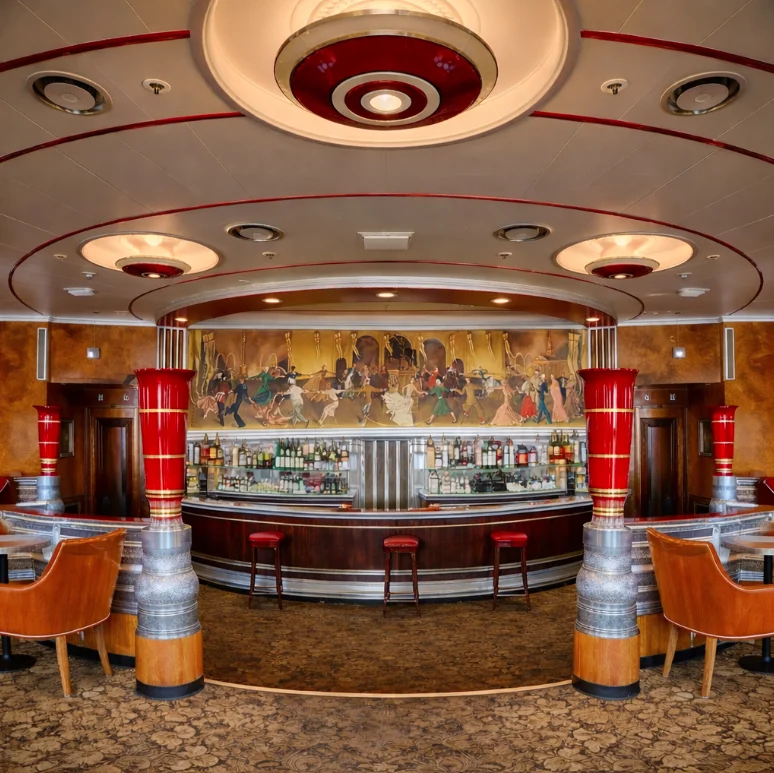 Interior view of an elegant vintage bar with red and silver columns, leather chairs, and a mural depicting dancers above the bar counter.
