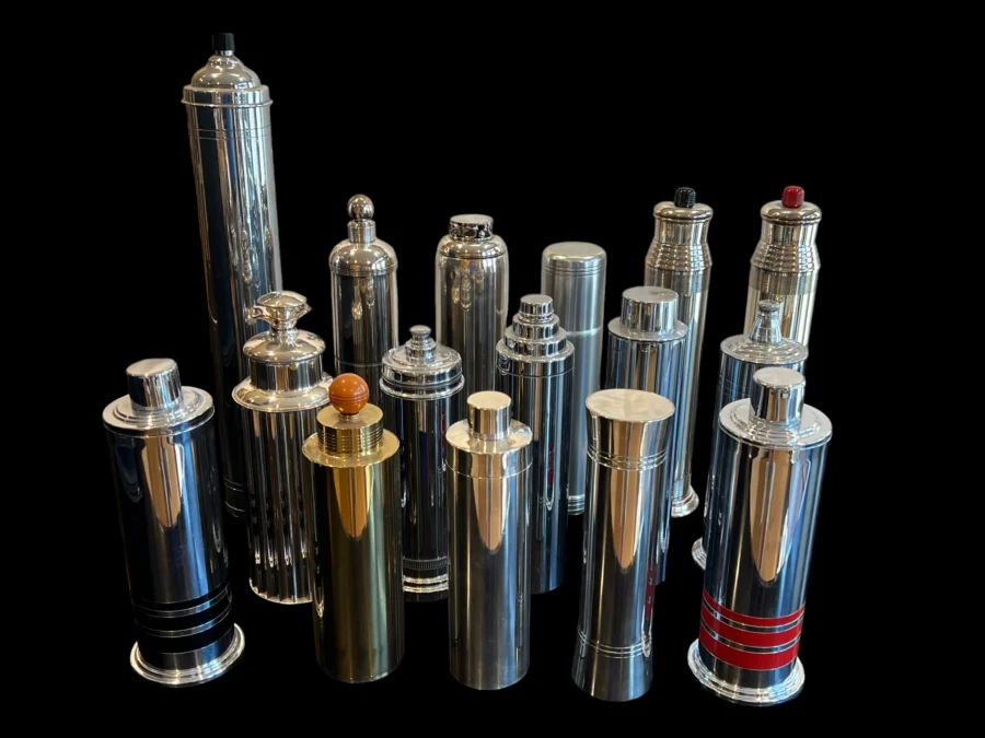 Collection of tall vintage chrome cocktail shakers on a black background