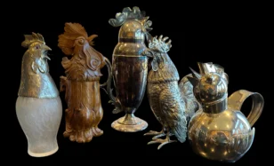 Five decorative rooster-shaped pitchers and jugs against a black background