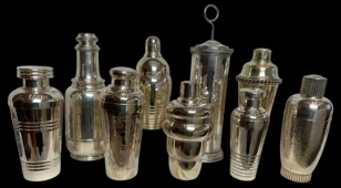 Collection of vintage silver cocktail shakers on a black background