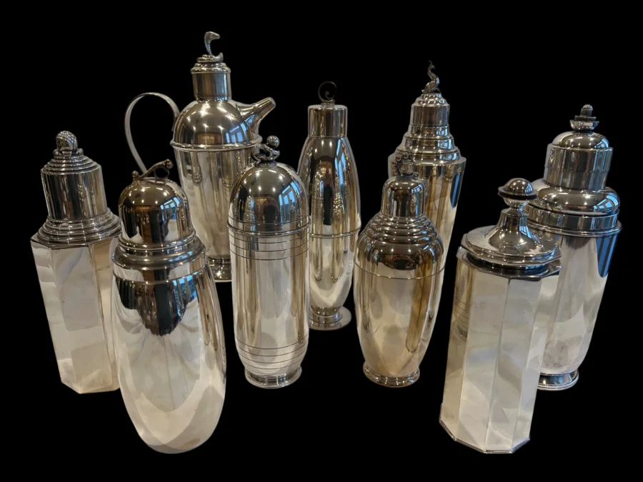 collection of vintage silver cocktail shakers on black background