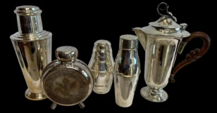 Set of vintage silver cocktail shakers and a silver coffee pot with wooden handle on black background