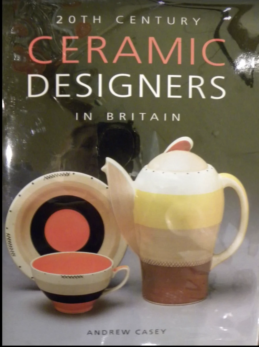 Cover of the book '20th Century Ceramic Designers in Britain' by Andrew Casey showing a ceramic teapot, cup, and saucer with bold red, black, yellow, and beige designs.