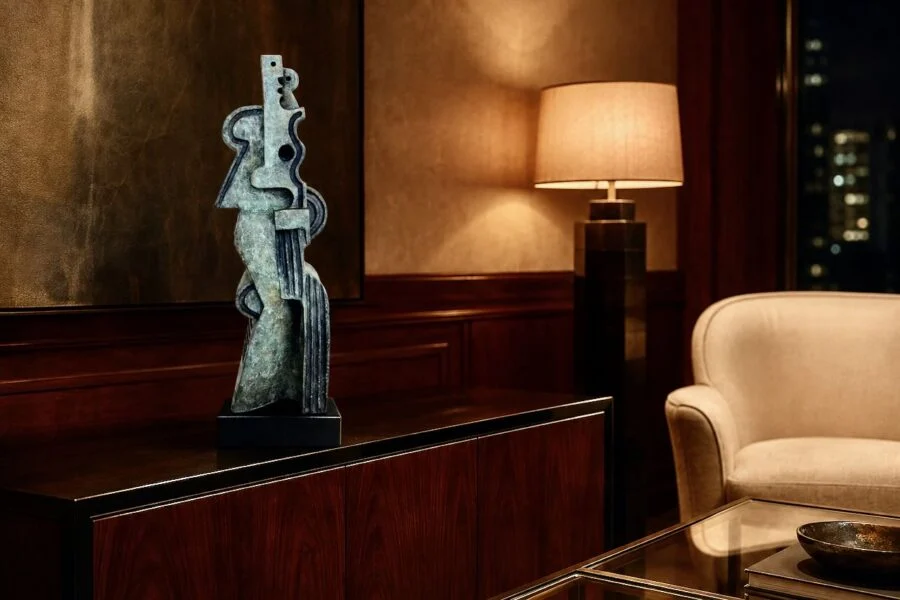 Abstract metal sculpture on a wooden cabinet in a warmly lit living room