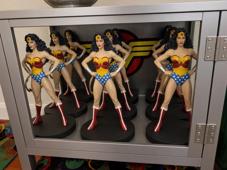 collection of Wonder Woman statues displayed in a glass cabinet