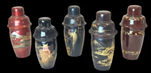 Set of five vintage Japanese-style lacquer cocktail shakers with gold landscape designs on a black background