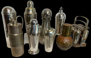Collection of vintage metal cocktail shakers on a black background